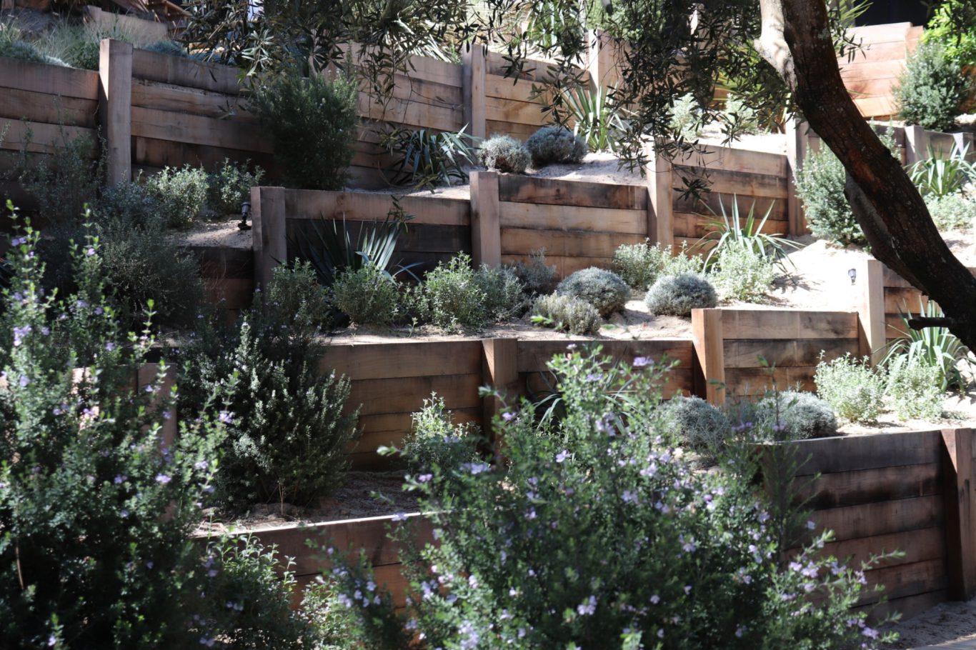 Mur de soutènement réalisé avec des poutres paysagères.